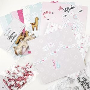 StickerKitten Alpaca Wishes Christmas paper pack - flatlay of papers, sequins, wooden alpacas