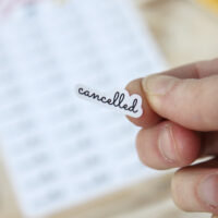 StickerKitten Cancelled Scripty Text Planner Stickers - closeup on finger