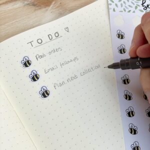 Bullet journal with cute bee stickers for bullet points