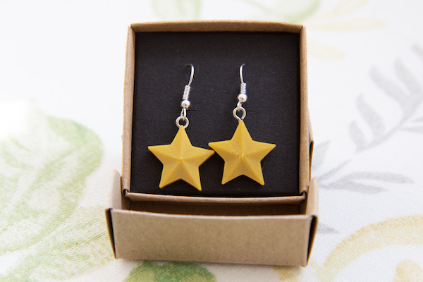 gold star earrings in box