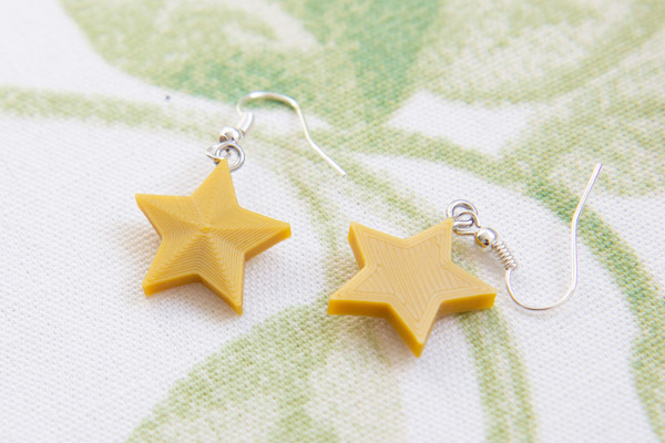 3D-printed gold star christmas earrings front and back
