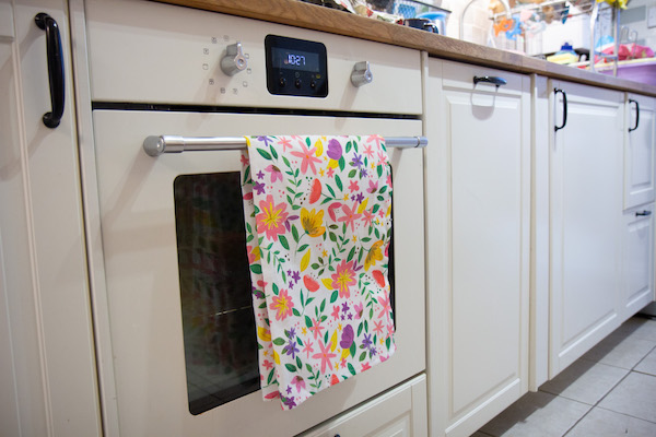 floral tea towel hanging on an oven handle