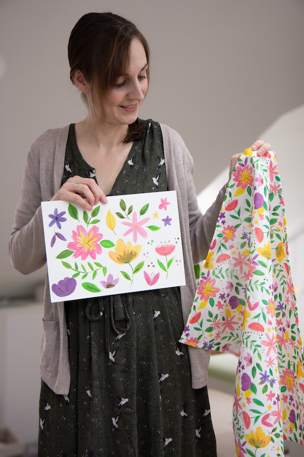 Sarah holding up the original floral artwork next to the printed tea towel
