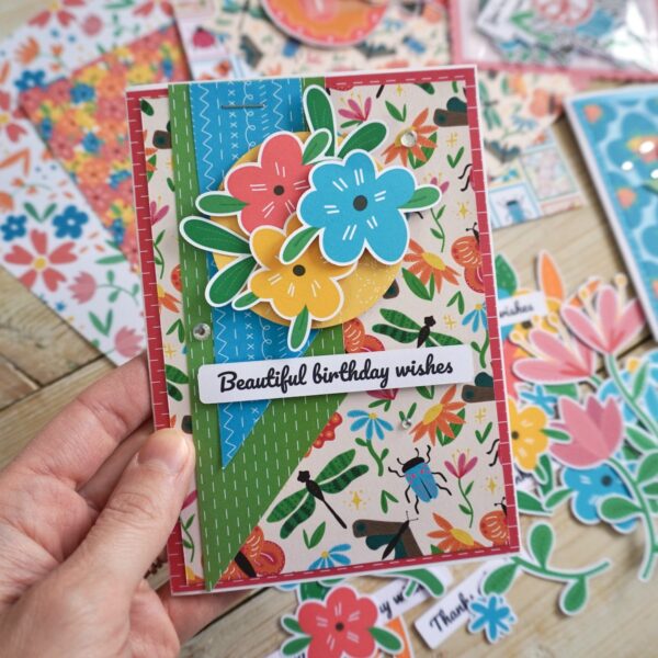 Bright and colourful Bold Floral handmade card with patterned bugs paper and paper flower toppers