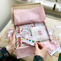 Gingerbread Christmas cardmaking kit by StickerKitten in a cardboard mailer box with pink tissue paper and freebie mini sticker sheet