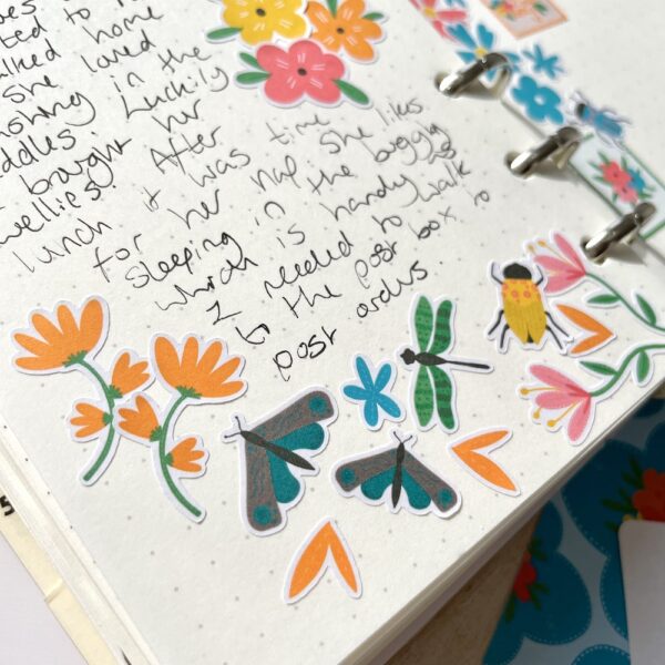 Dot grid journal with text, decorated with flower and bug stickers