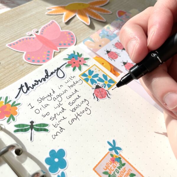 Writing in a journal decorated with stickers