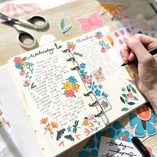 Open journal with writing decorated with stickers