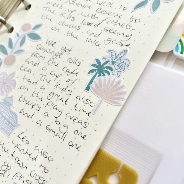 Palm tree stickers and writing on a dot grid journal page