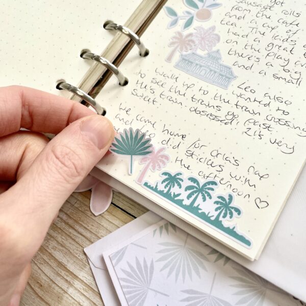 Palm tree stickers and writing on a dot grid journal page