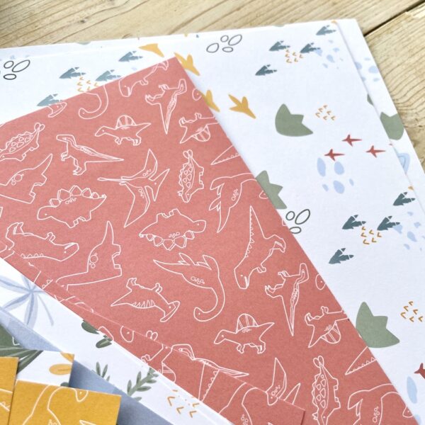 Cute tumbling dinosaurs and dinosaur footprint patterned paper designed and made by StickerKitten UK