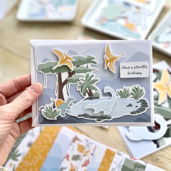 Handmade dinosaur card with cute mini dinosaurs, tree and pool scene