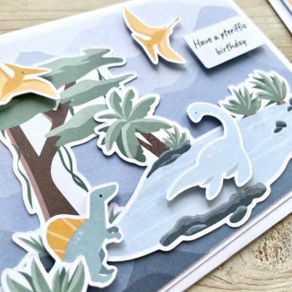 Handmade dinosaur card with cute mini dinosaurs, tree and pool scene